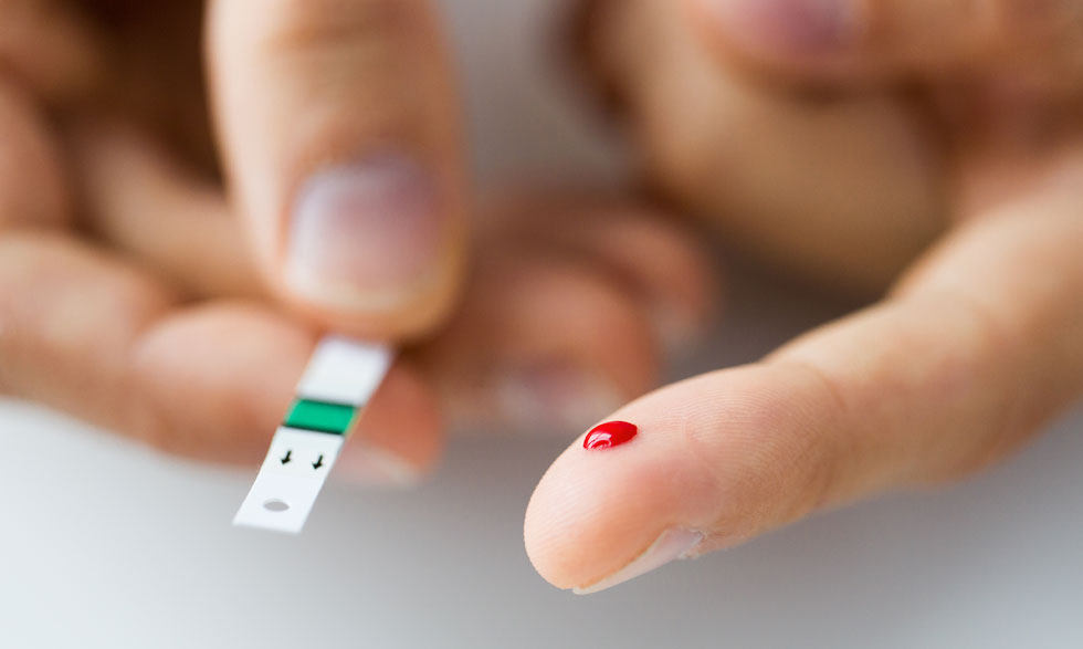 Person uses a finger stick to test blood glucose.  